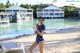 A woman in a polka dot swimsuit standing on a beach.