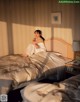 A woman sitting on a bed in a hotel room.