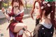 Two women in traditional attire, one smoking, surrounded by cherry blossoms.