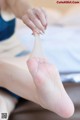 A woman is putting a bandage on her foot.