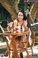 A woman sitting at a table eating a bowl of food.