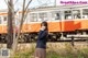 A woman in a school uniform standing next to a train.