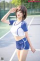 A woman in a blue and white outfit on a tennis court.