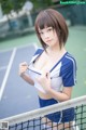 A woman in a blue and white outfit holding a tennis racket.