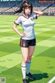 A woman standing on a soccer field with her hands on her hips.