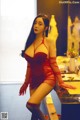 A woman in a red lingerie posing in front of a mirror.