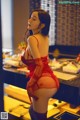 A woman in a red lingerie standing in front of a mirror.