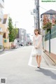 A woman walking down the street carrying a bag.