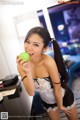 A woman in lingerie holding an apple in her hand.