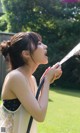 A woman holding a hose with water coming out of it.