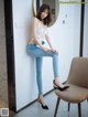 A woman sitting on a chair in front of a mirror.