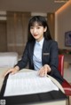 A woman in a business suit sitting at a table.