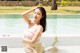 A woman in a pink bikini sitting in a pool.