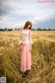 A woman standing in a field of tall grass.