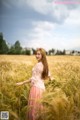 A woman standing in a field of tall grass.