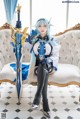 A woman sitting on a couch holding a sword.