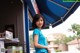 A woman standing in front of a blue awning.