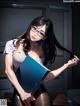 A woman sitting on a desk holding a book.